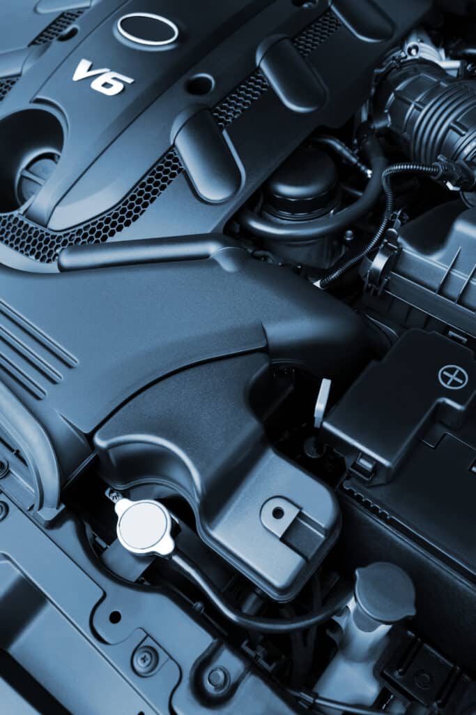 Moteur de voiture V6 moderne, avec son cache noir et des grilles hexagonales. Détails du compartiment moteur.
